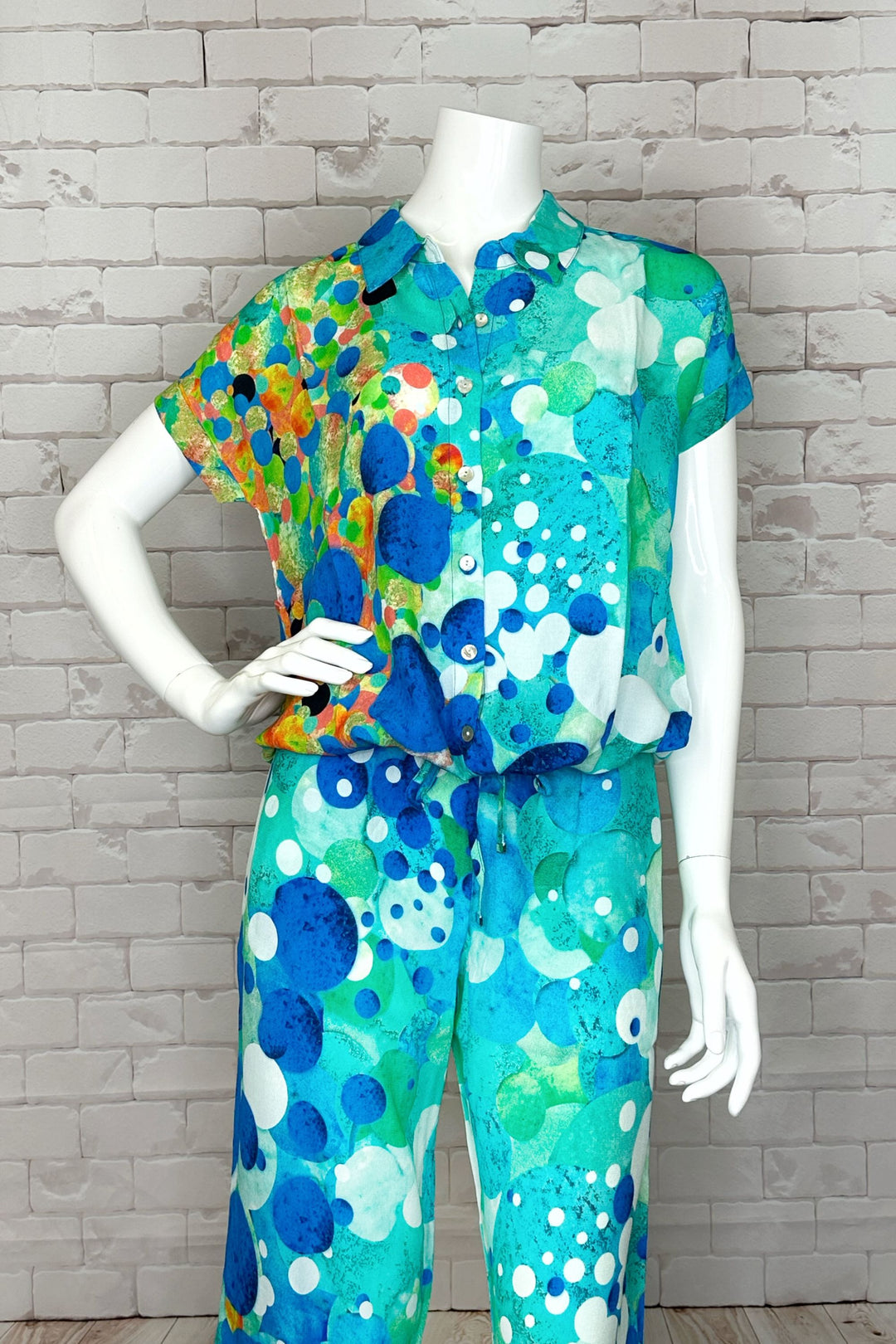 This Big Angel Fish Mosaic blouse is a vibrant and versatile piece, featuring short sleeves, front buttons, a tie waist and a capitivating big bold fish artistic pattern. 