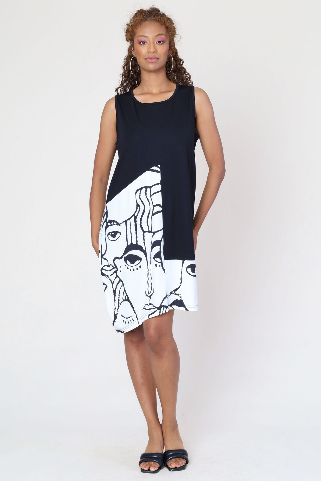 Funsport Summer 2024  Featuring an abstract face print that's sure to turn heads and a flattering boat neckline. The uneven double stitch hem adds a playful twist to this knee-length dress. 