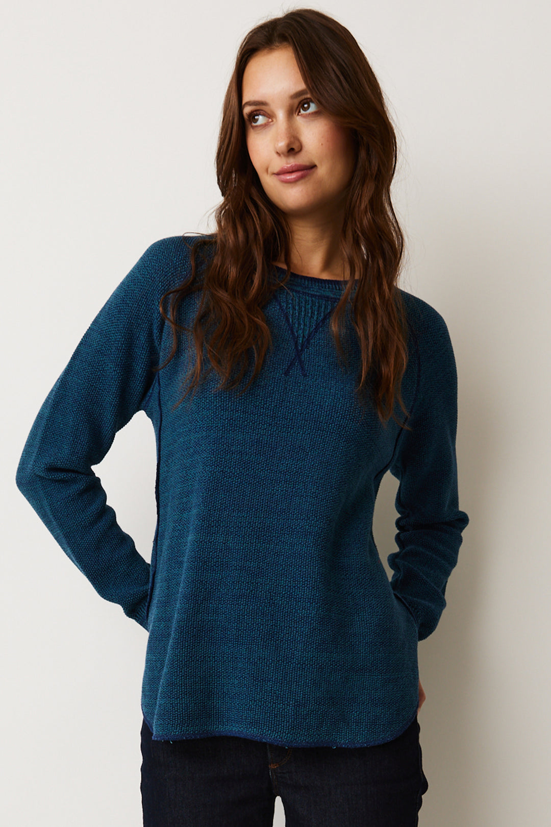 It features a unique raglan shoulder detail as well as a shirttail hem on both the front and back. Its full length sleeves provide comfort and warmth in all seasons.