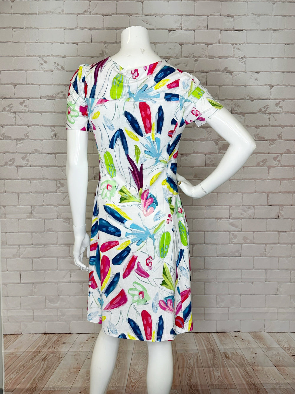 Its short sleeves and abstract tropical design pattern add a touch of versatility and beauty.