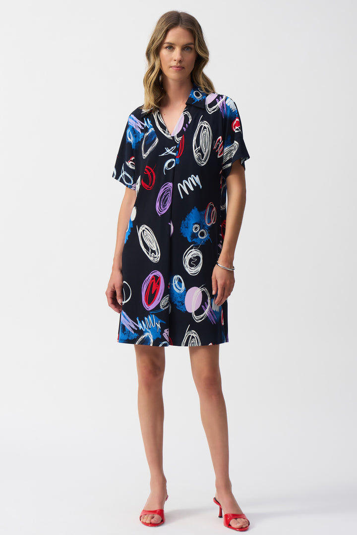 Joseph Ribkoff Spring 2025 With a flattering fit and open v-neck, this dress will turn heads! The sweet scribbles add a charming touch to the light and loose fabric.