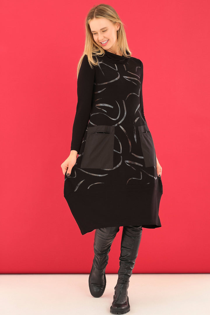 Dolcezza Fall 2025 
This elegant A-line midi dress blends classic black with subtle light tones for a sophisticated look. Designed with full-length sleeves and a flattering cowl neck, it offers comfort and style for any occasion. 