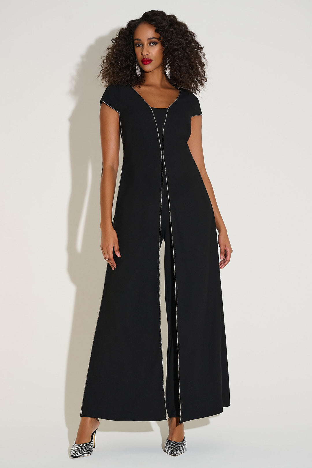 Woman wearing a black jumpsuit with a zipper on a white background