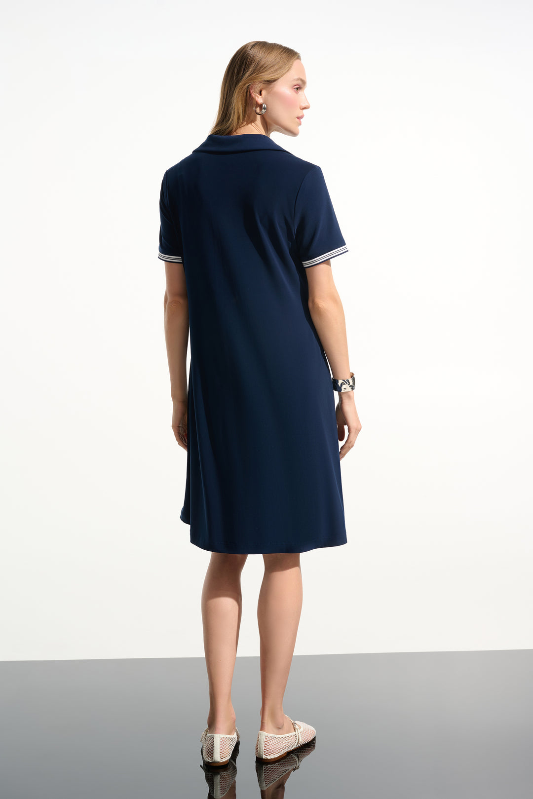 Woman wearing a navy blue dress on a white background