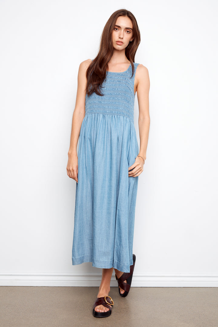 Woman wearing a light blue dress against a white background