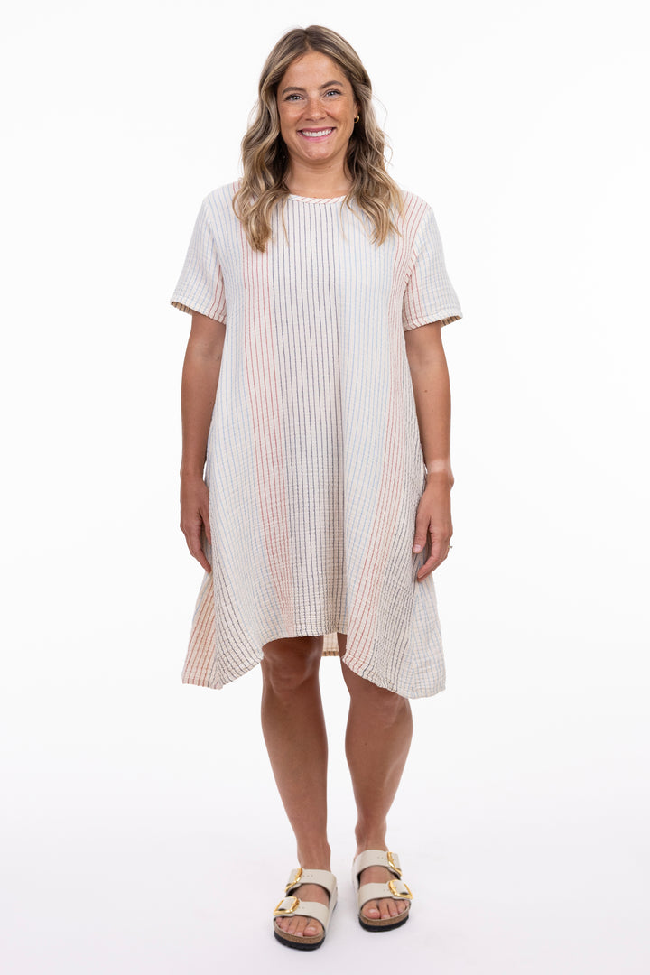 Woman wearing a white dress with a subtle pattern on a white background