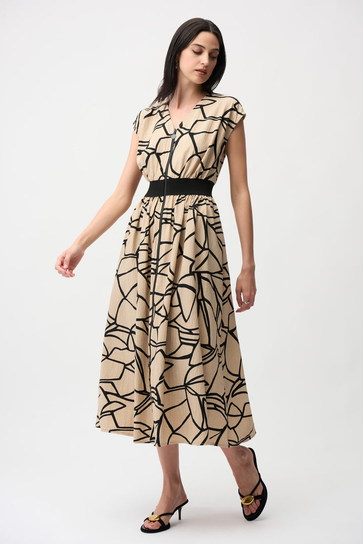 Woman wearing a beige dress with black abstract pattern on a white background