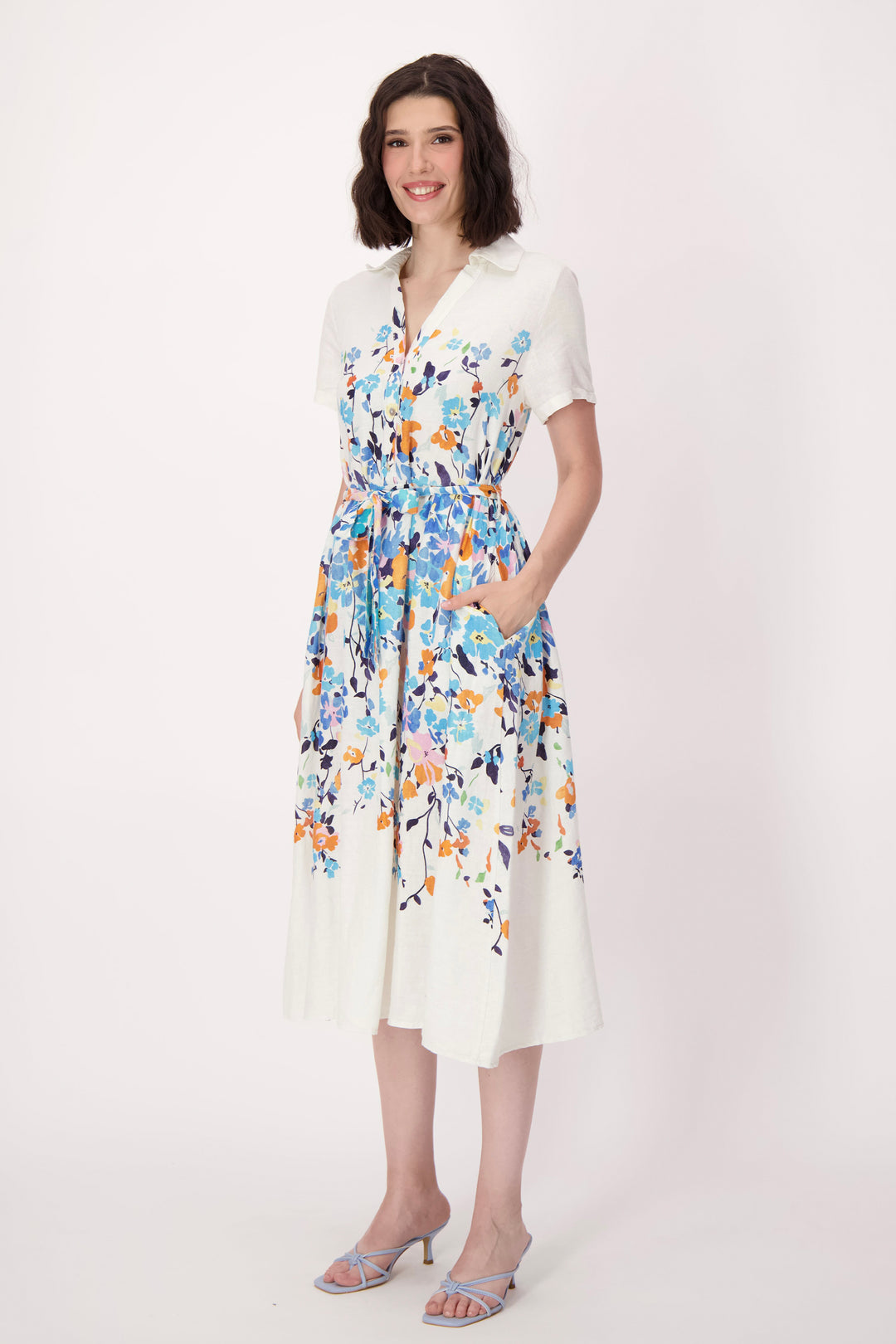 Woman wearing a belt floral dress with a white background