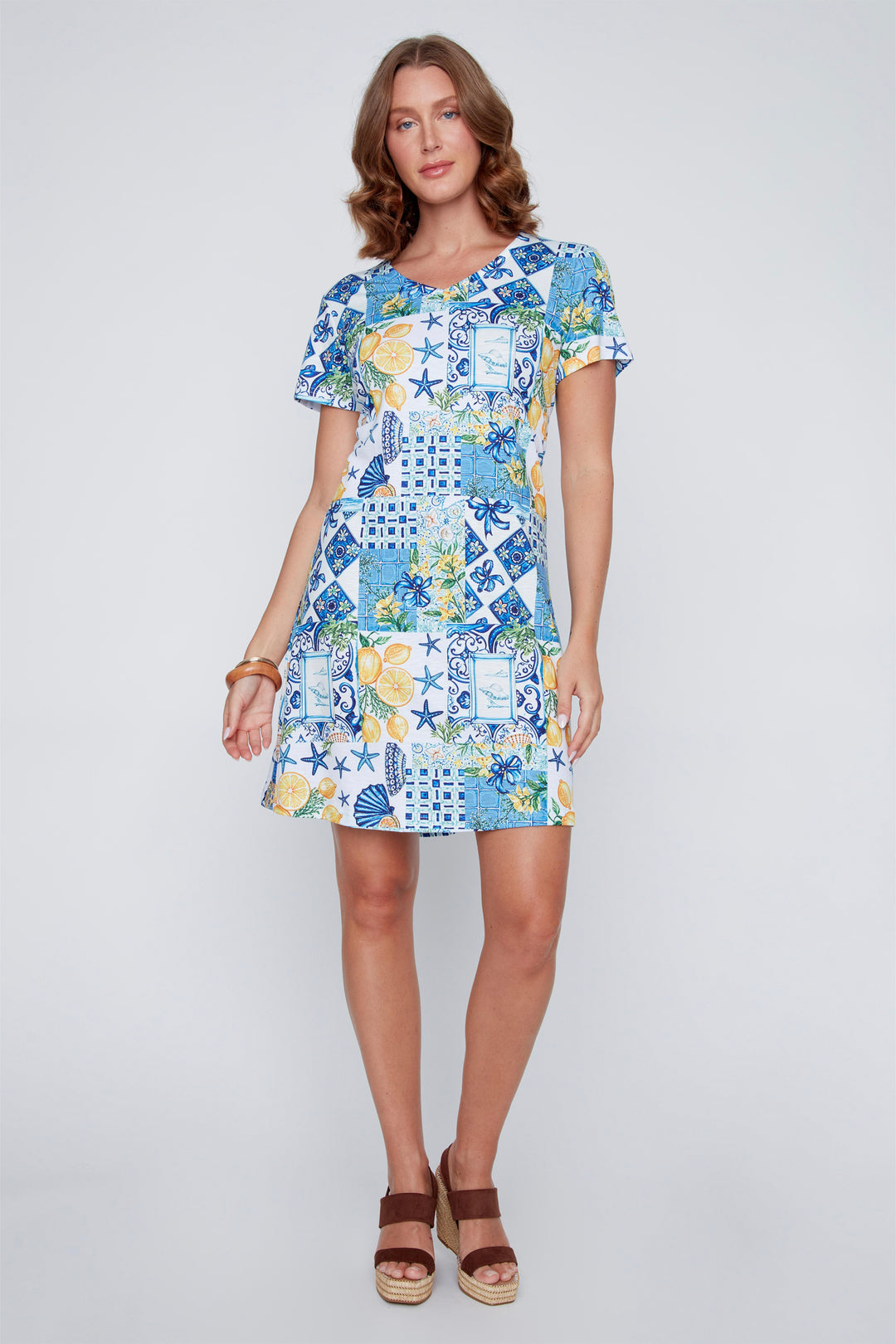 Woman wearing a colorful patchwork short sleeve summer dress on a white background