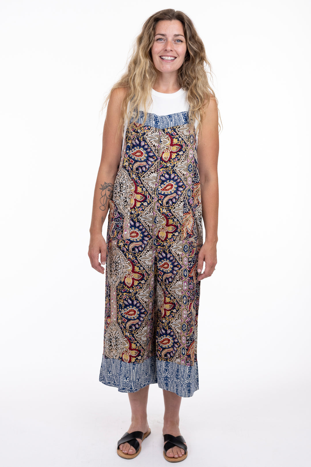 Woman wearing a patterned one piece button overall on a white background