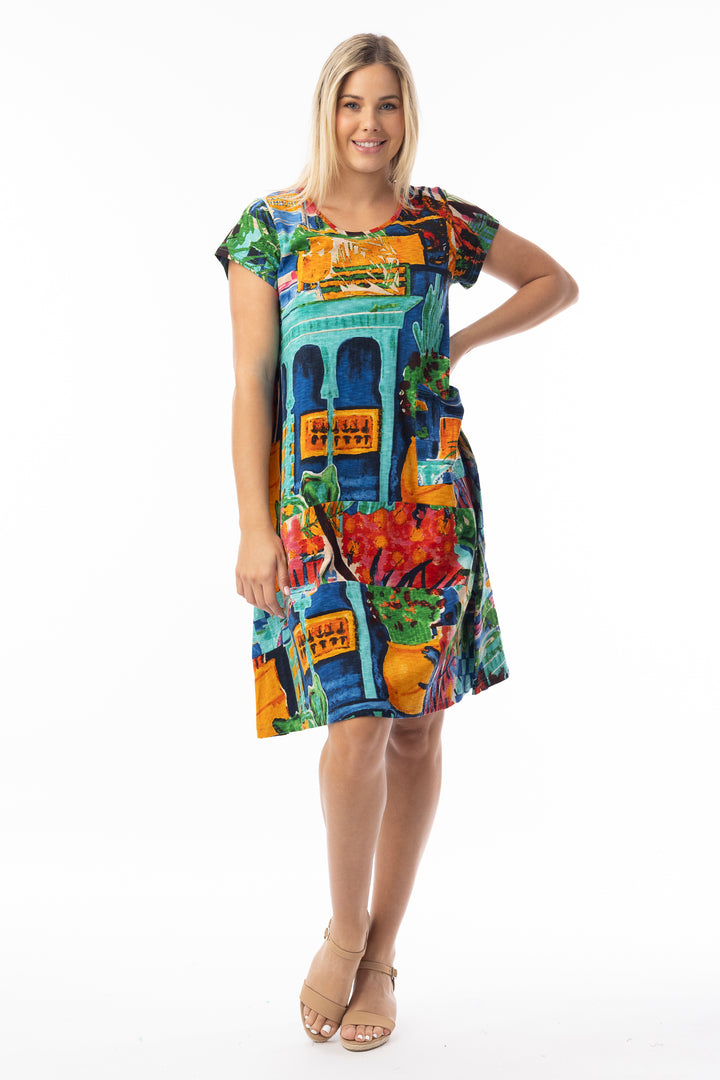 Woman wearing a colorful shift summer dress with a pattern on a white background