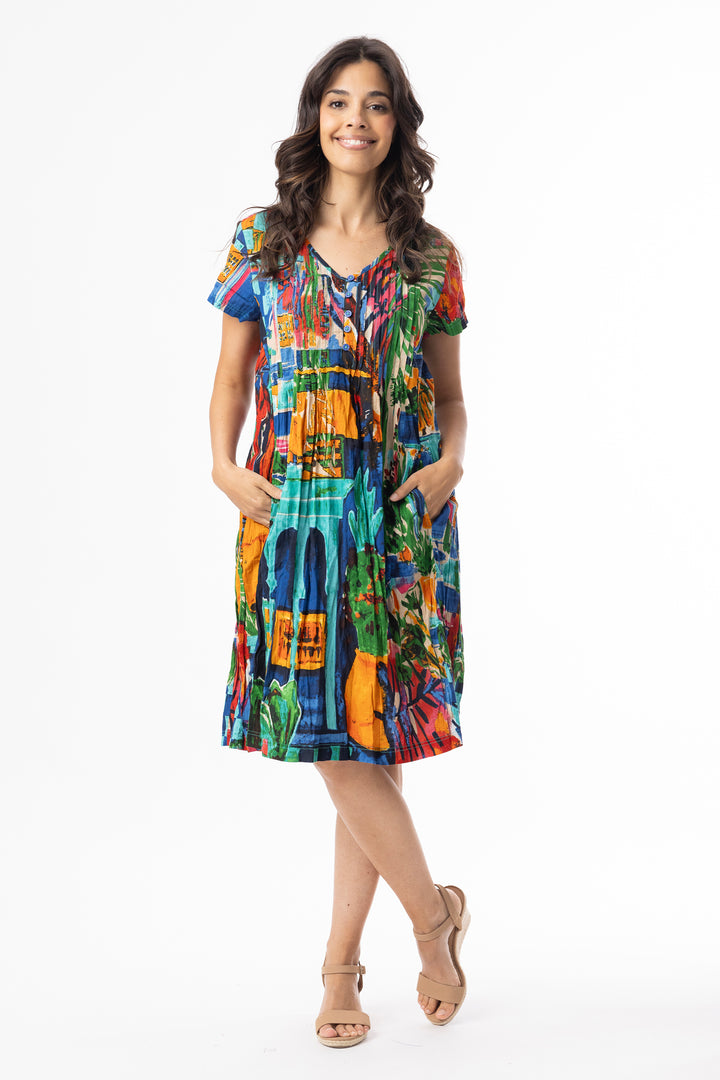 Woman wearing a colorful v-neck, short sleeve crinkle dress on a white background