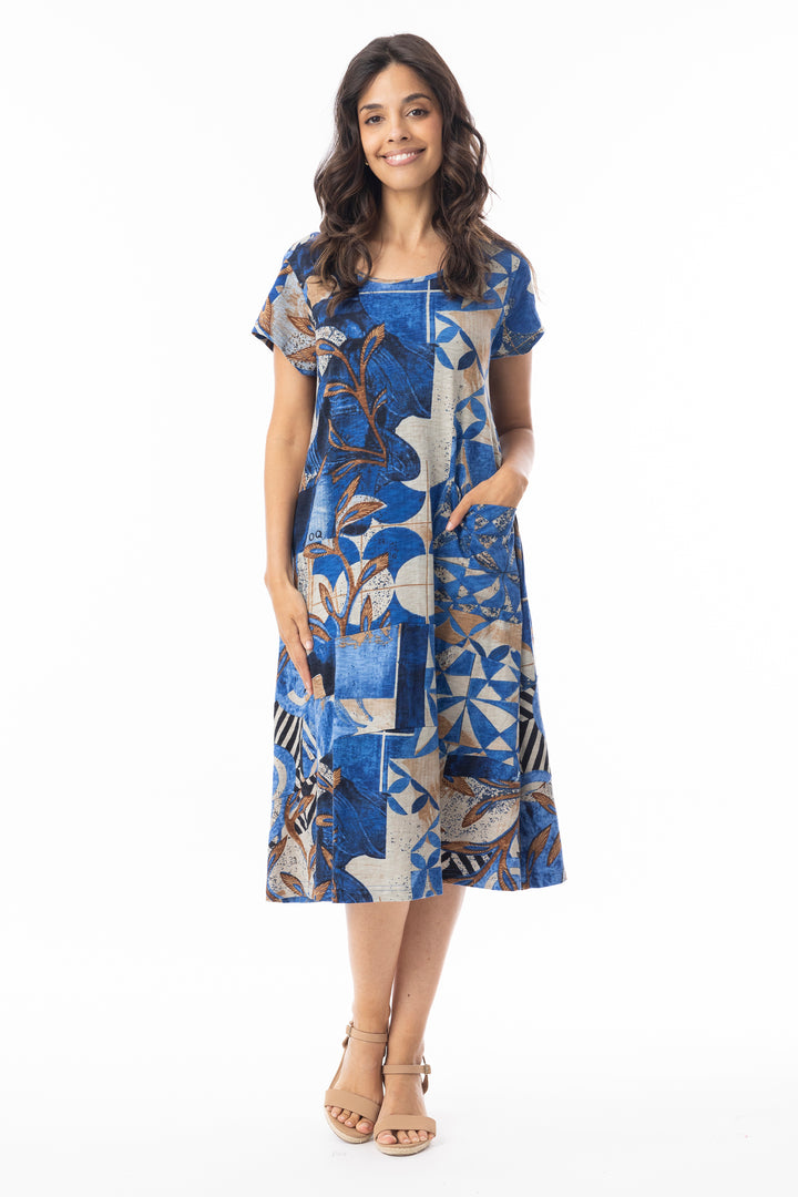 Woman wearing a blue patterned dress  with short sleeves on a white background