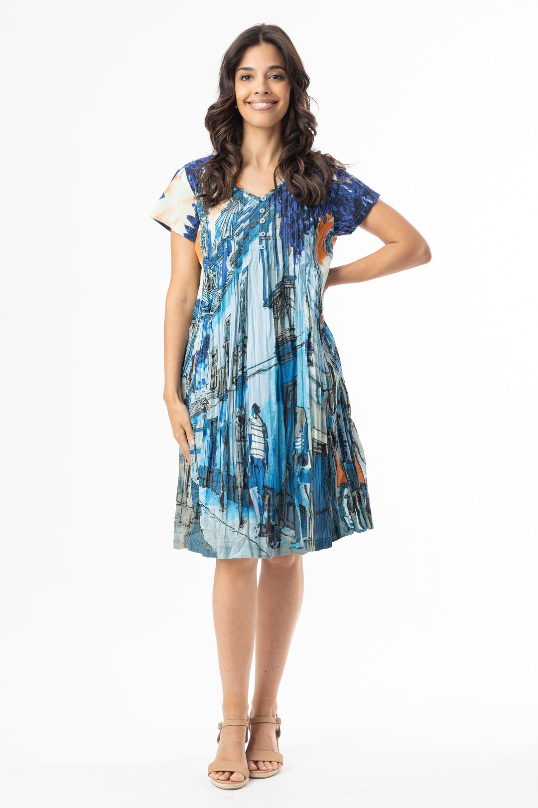 Woman wearing a blue and gray patterned dress with button v-neck and short sleeves on a white background