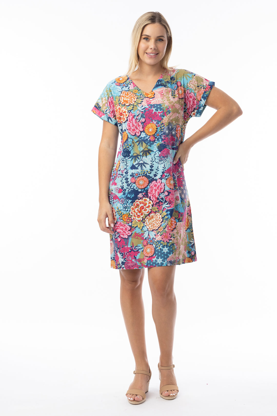 Woman wearing a colorful floral v-neck dress on a white background