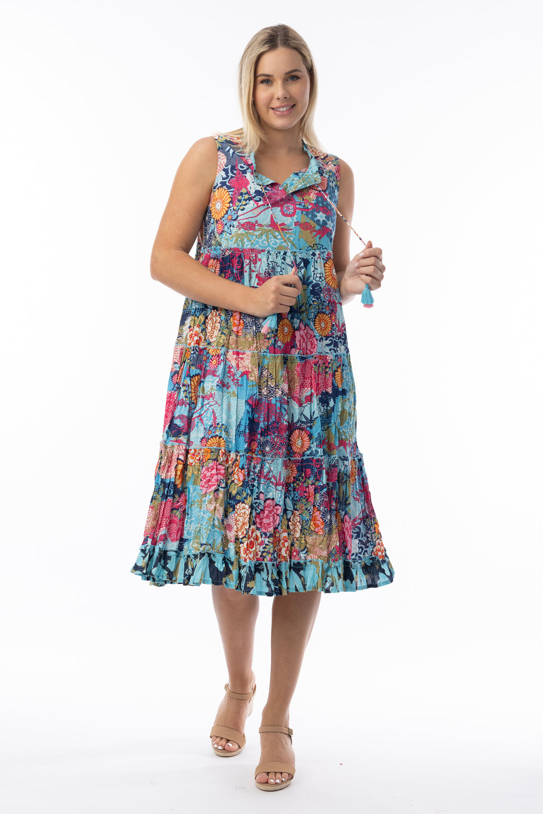 Woman wearing a colorful floral sleeveless dress on a white background