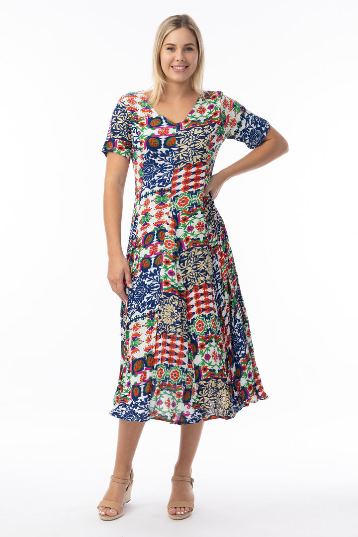 Woman wearing a colorful patterned v-neck, short sleeve dress on a white background