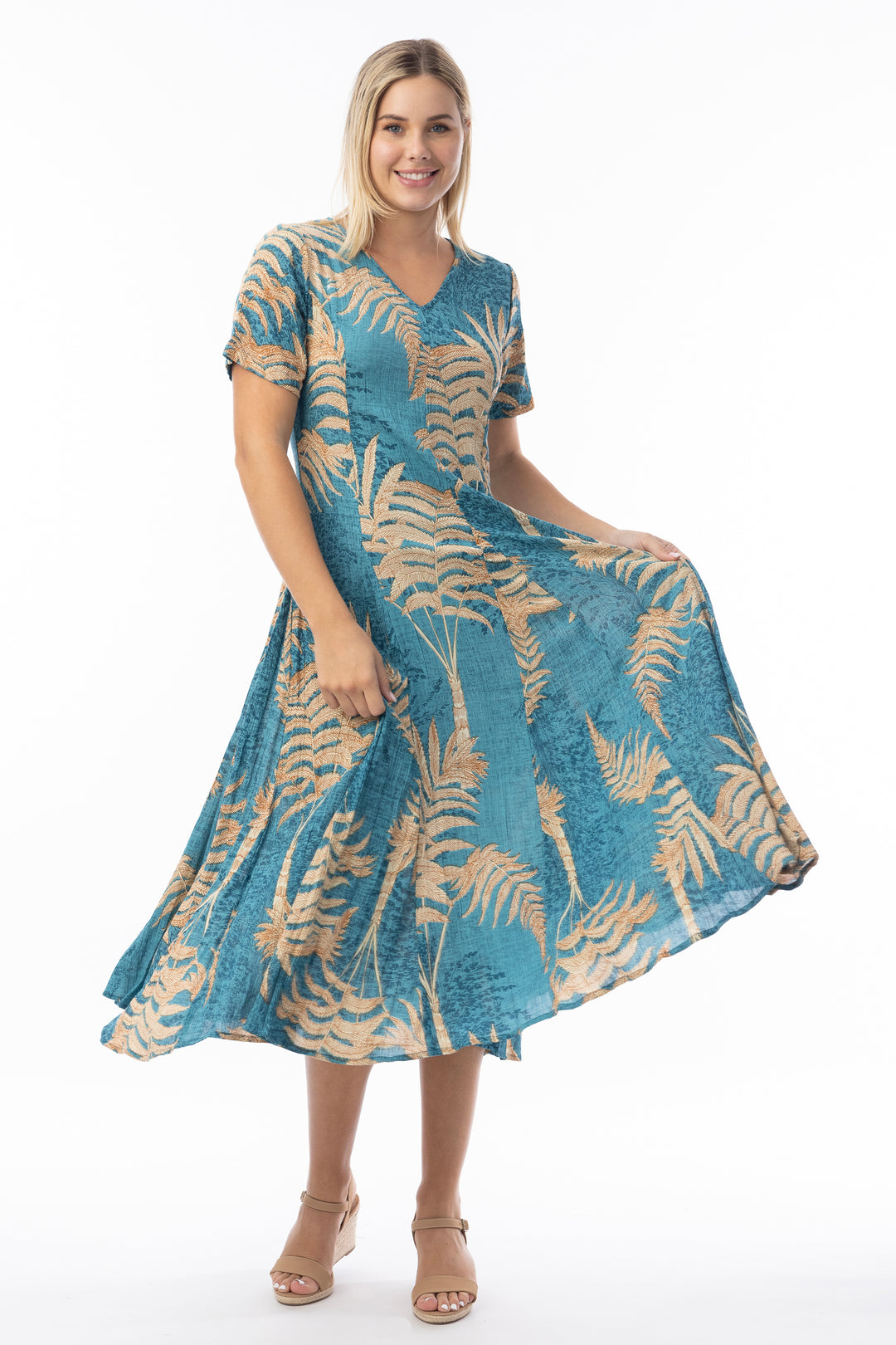 Woman wearing a blue and beige patterned v-neck short sleeve dress on a white background