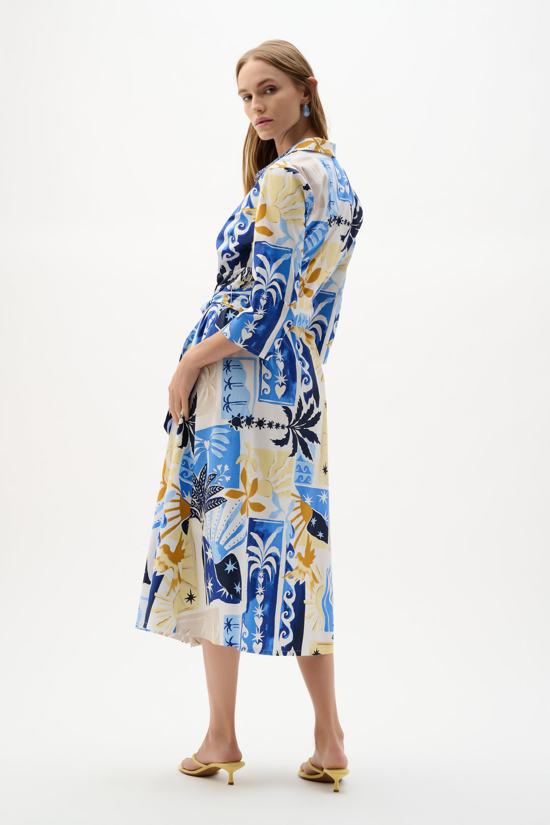 Woman wearing a colorful patterned dress on a white background