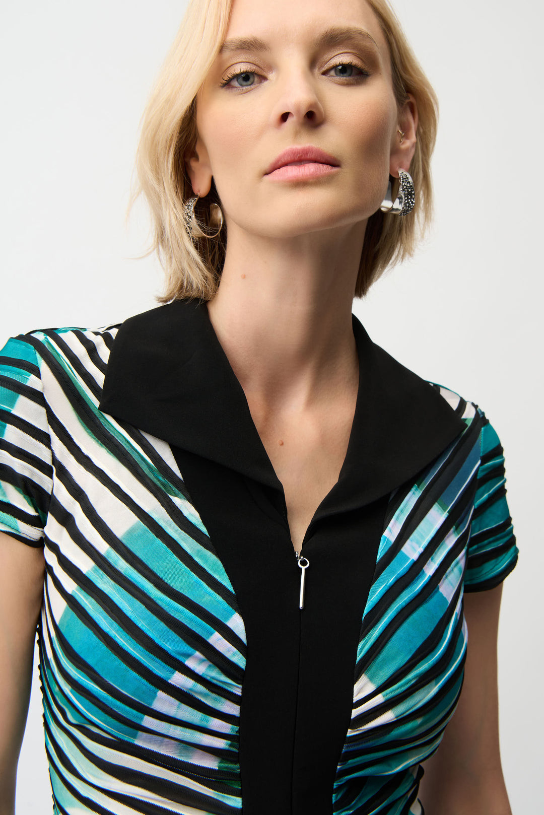 Woman wearing a black and multicolored striped dress against a white background