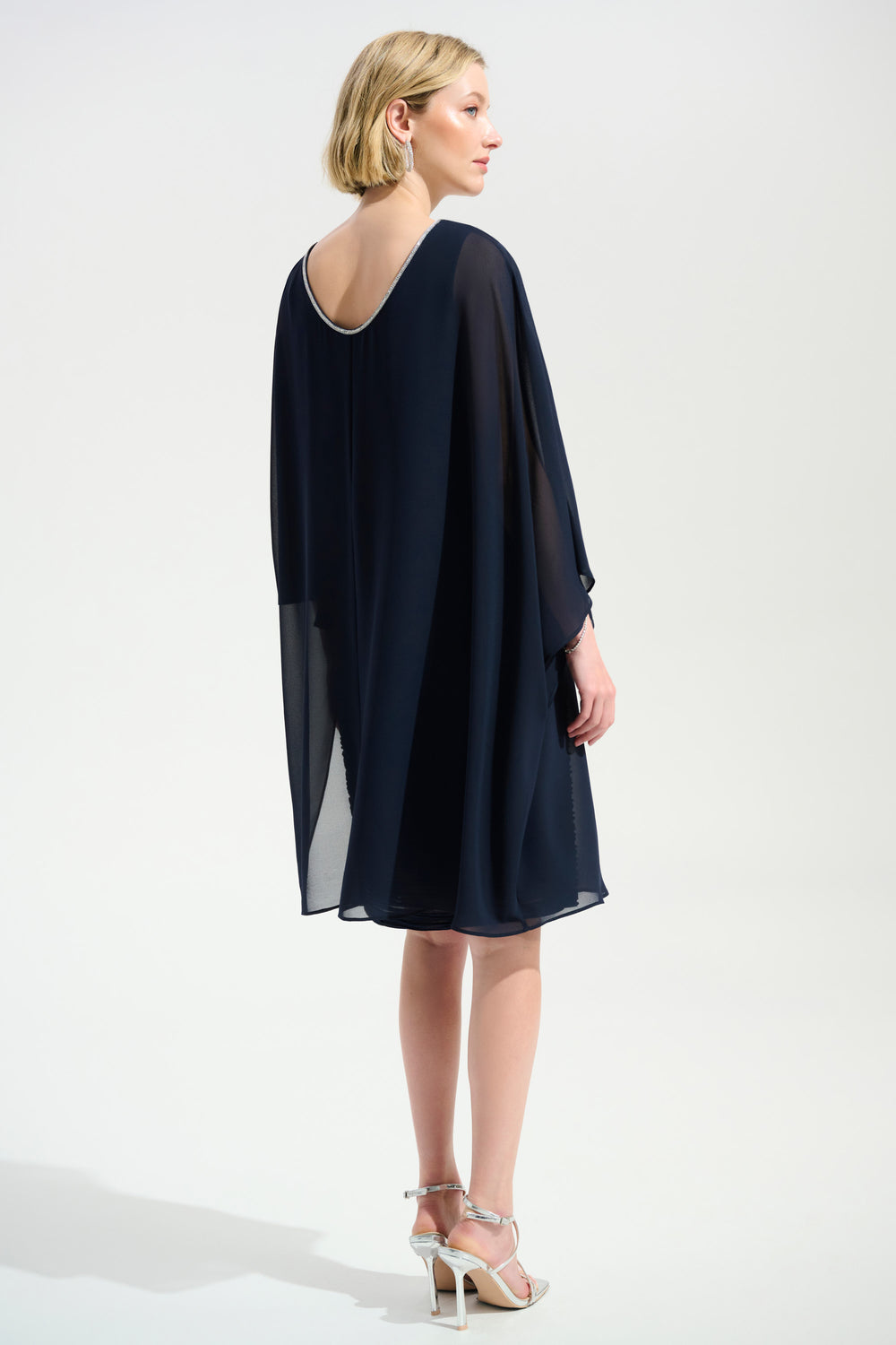Woman wearing a navy blue dress with a white background