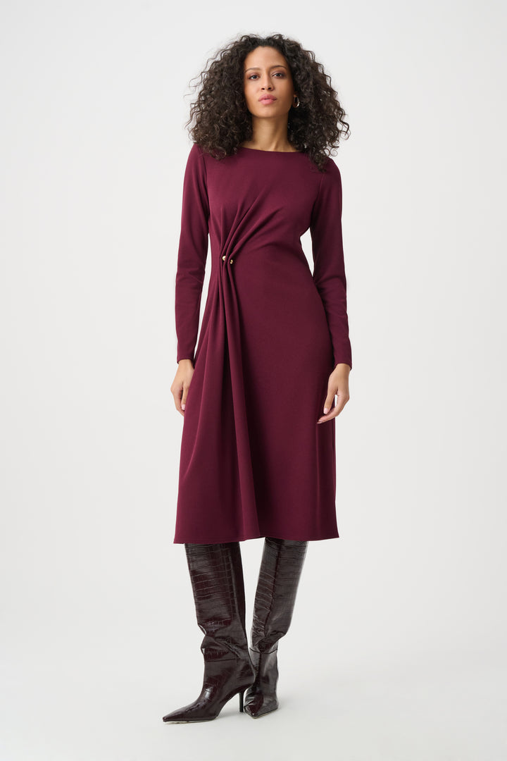 Woman wearing a burgundy dress with a white background