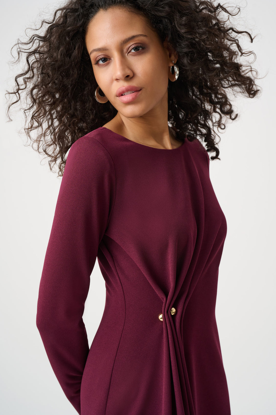 Woman wearing a burgundy dress with a white background