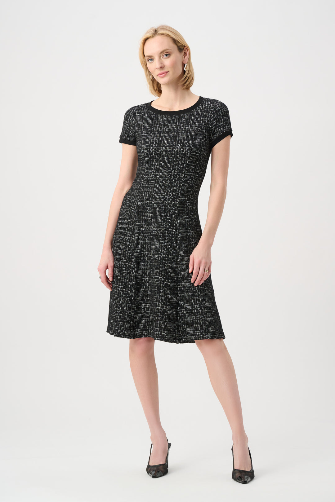 Woman wearing a black and white patterned dress on a white background