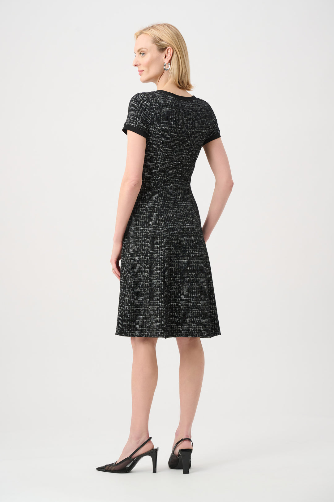 Woman wearing a black and white patterned dress on a white background