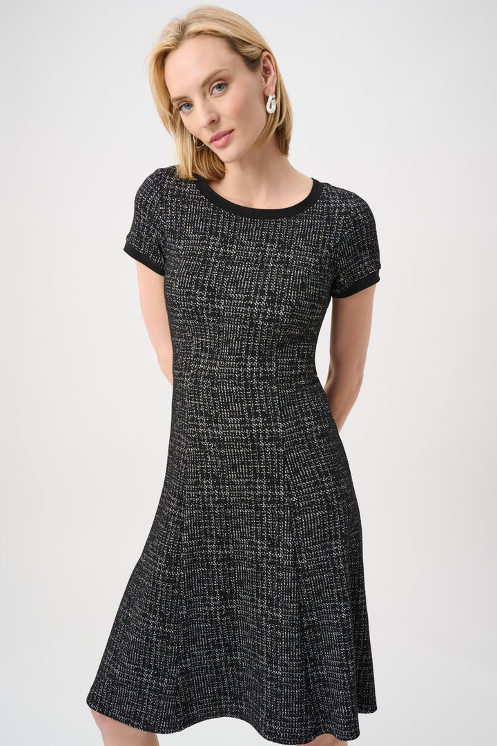 Woman wearing a black and white patterned dress on a white background