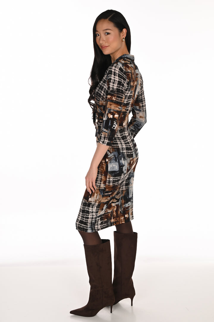 A woman shown from the back modelling a multi patterned brown dress with brown boots in front of a white background. 