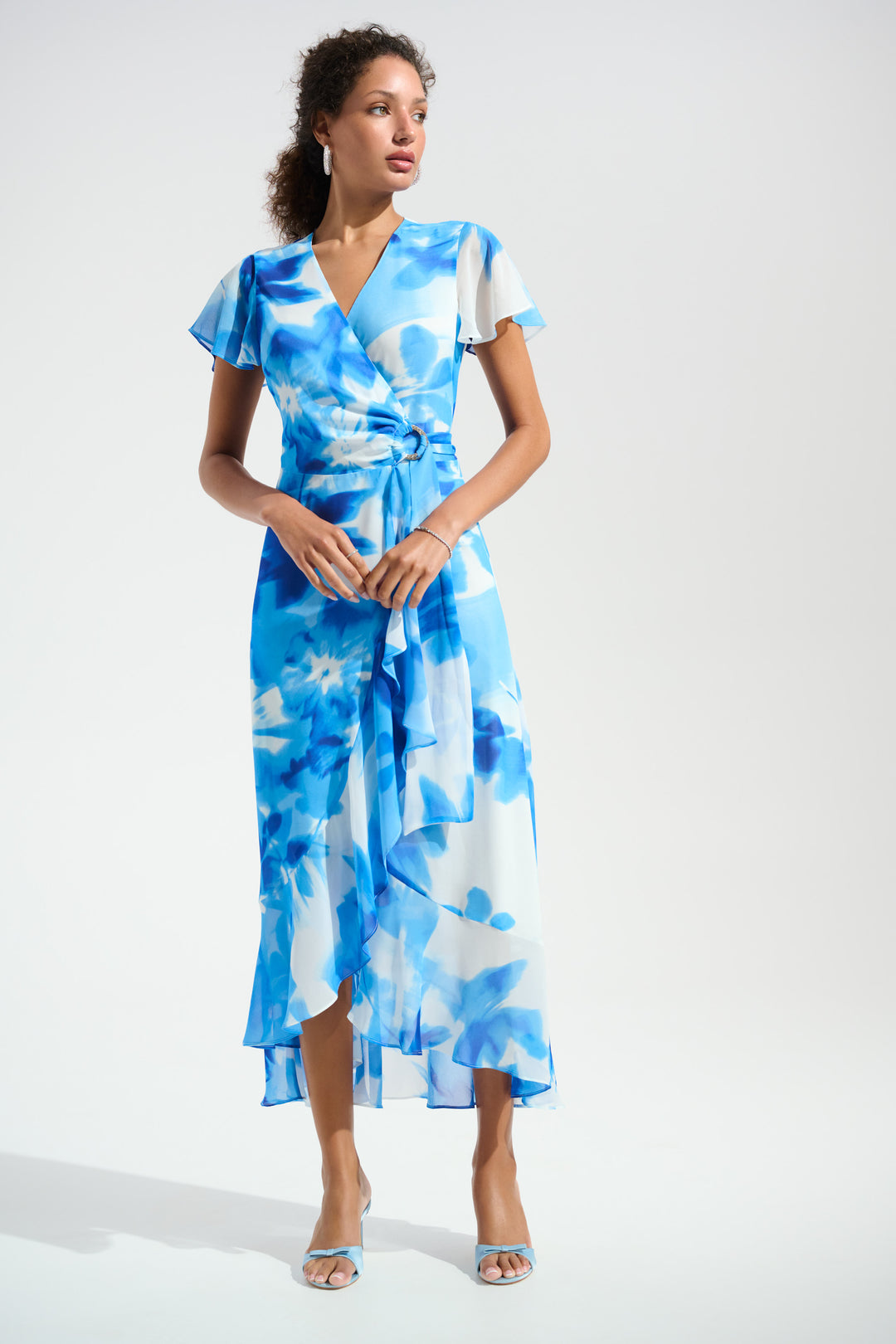 Woman wearing a blue floral dress against a white background