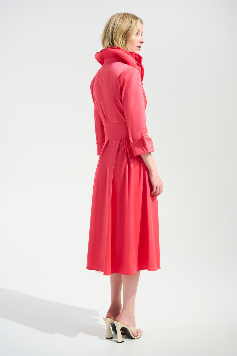 Woman wearing a pink dress with a hood on a white background