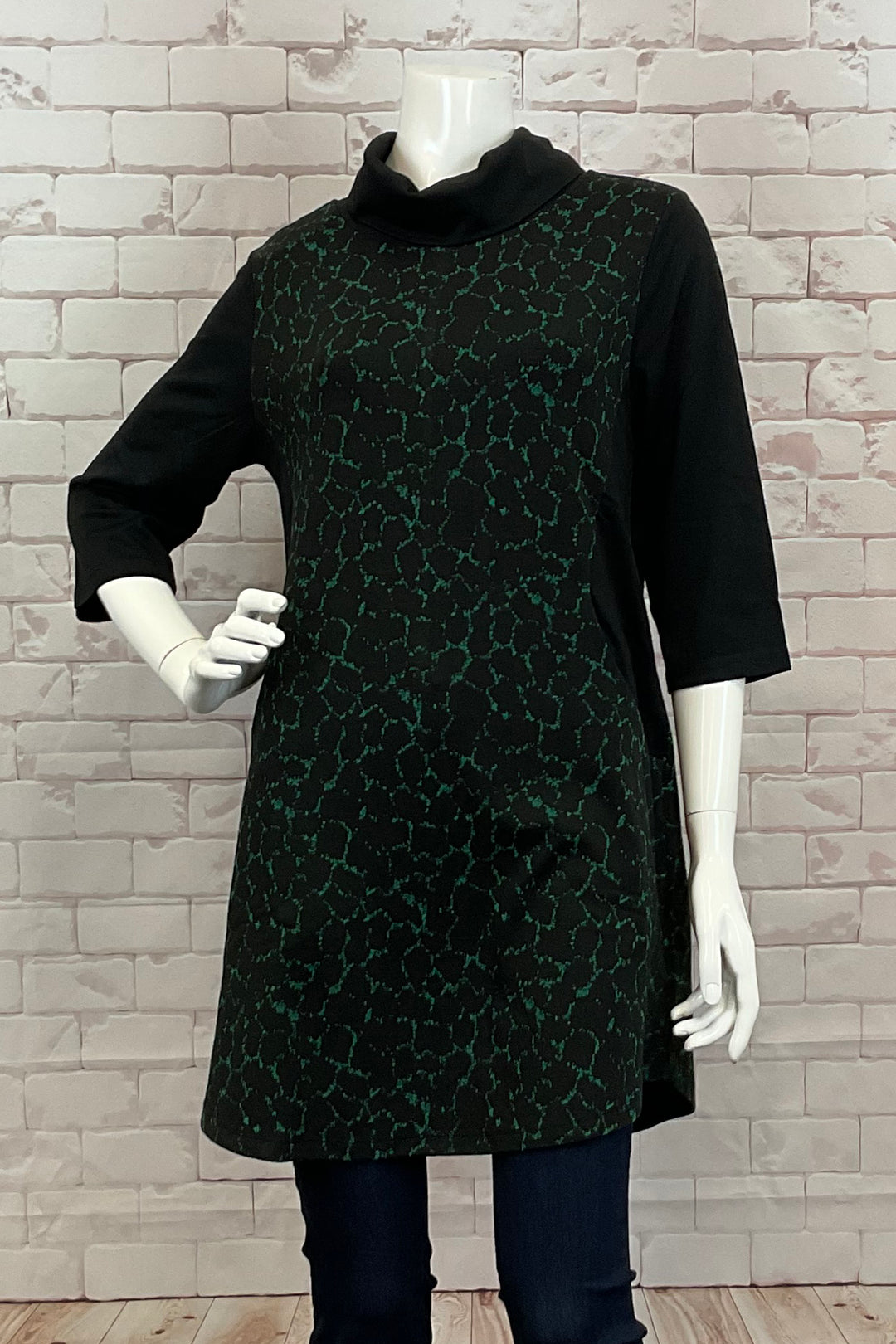 Ever Sassy Fall 2024 This stylish top features a flattering tunic length and a cozy cowl neck, perfect for the upcoming fall season. The neat contrasting cat walk print adds a unique touch to your wardrobe.