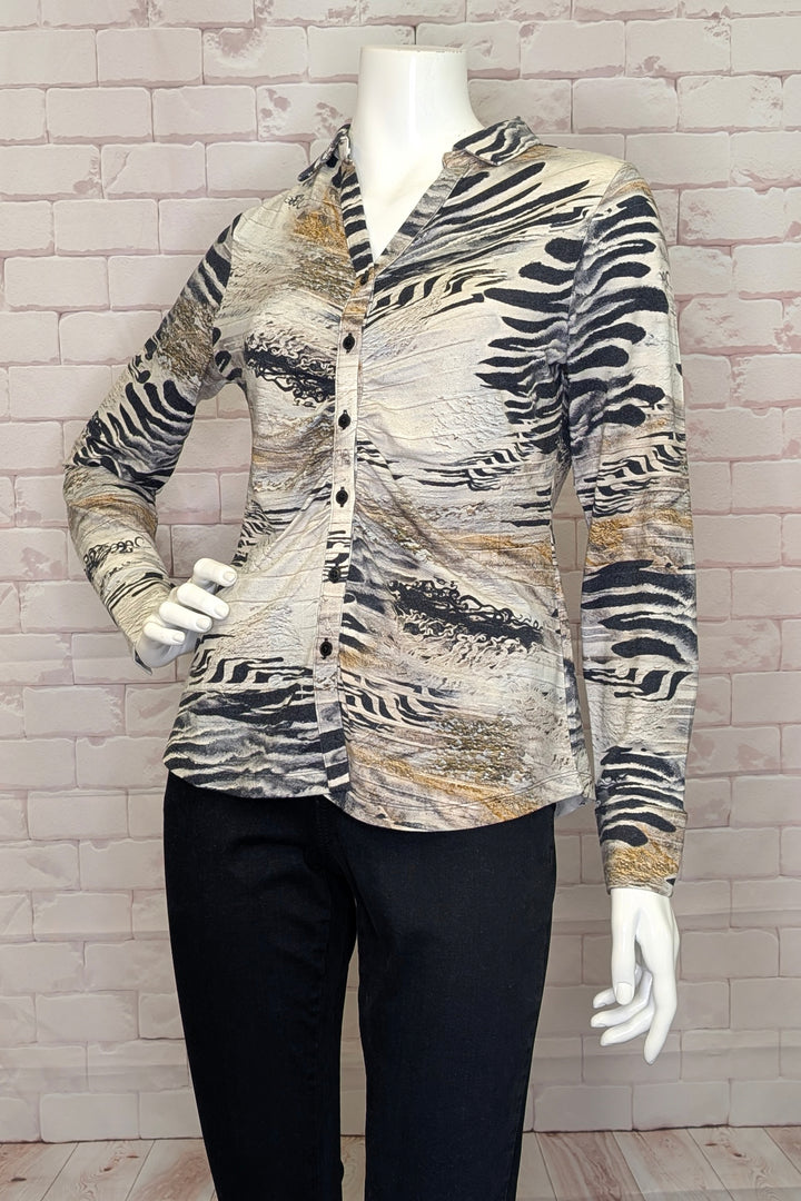 Dolcezza Fall 2025
 The open 'Y collar' and gathered front detail add a unique touch to this different type of blouse. Made from soft knit jersey fabric, it features front buttons and a curve hem.  