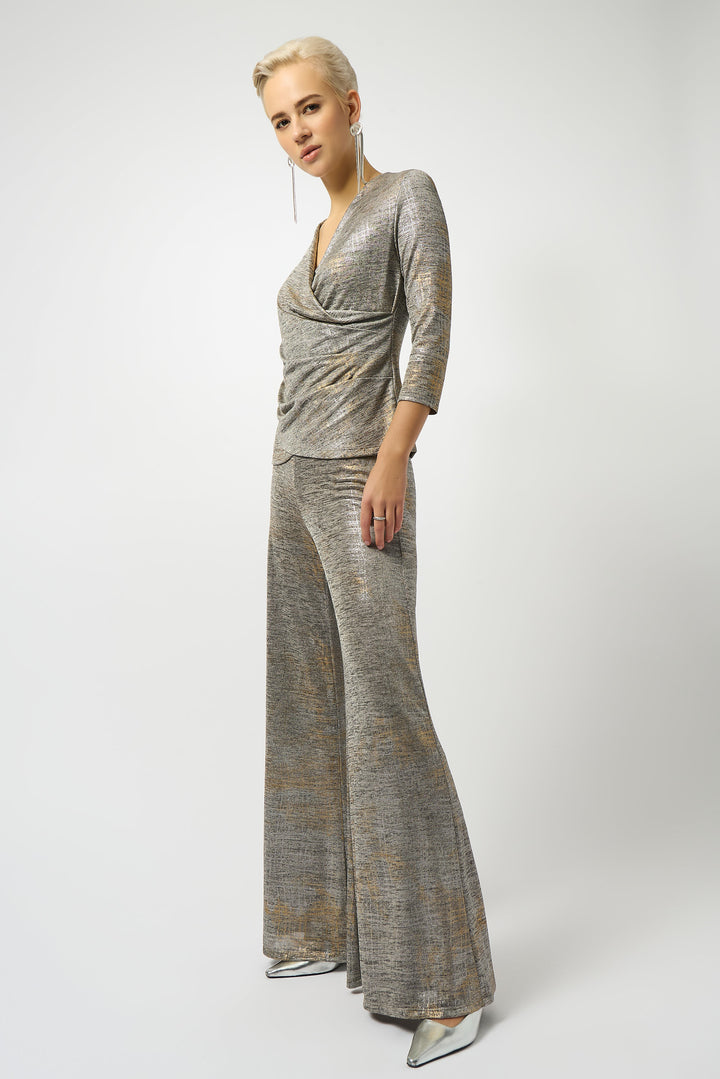 Woman wearing a silver metallic top on a white background