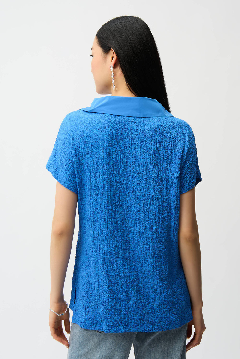 Person wearing a blue textured shirt on a white background