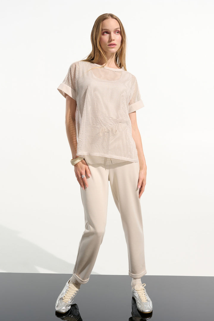 Woman wearing a beige outfit on a white background