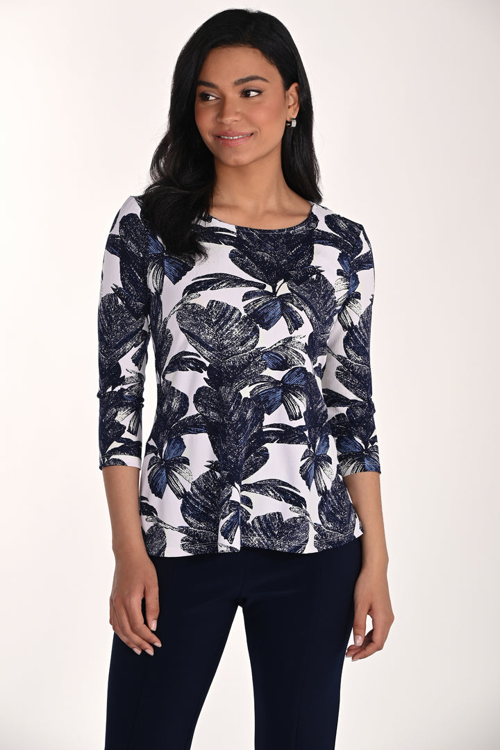 Woman wearing a navy floral patterned pullover top on a white background