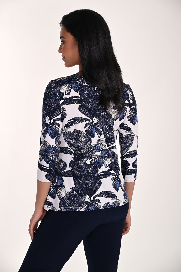 Woman wearing a navy floral patterned top on a white background 