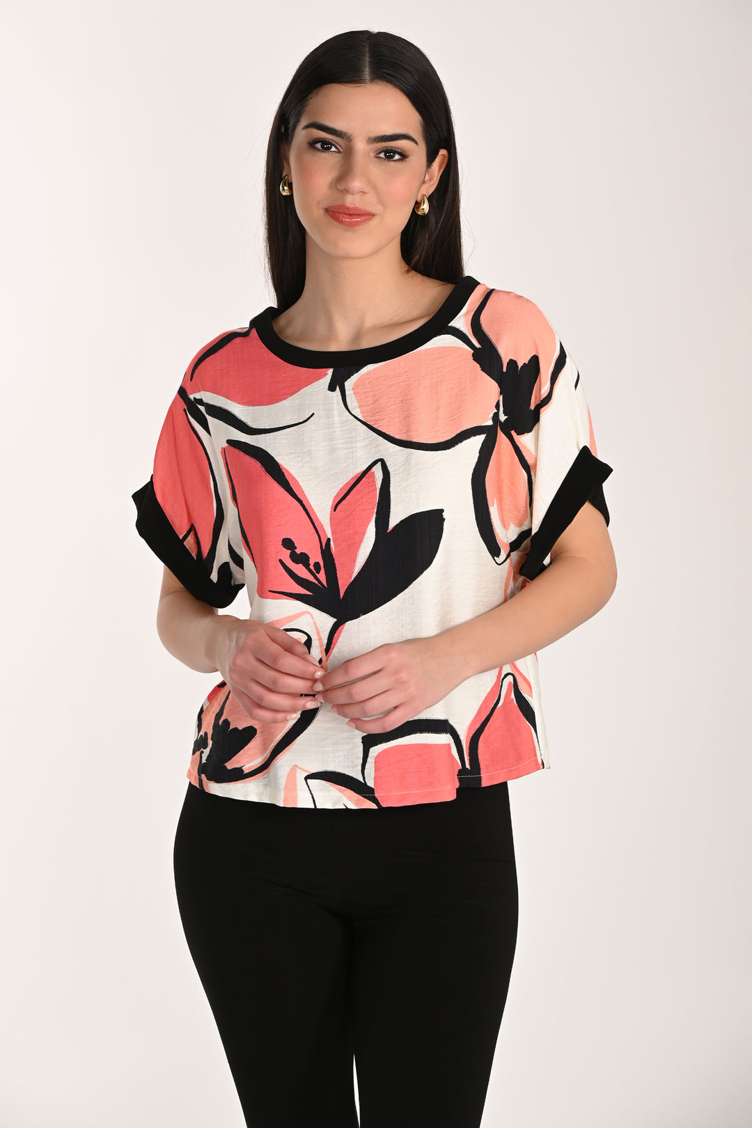 Woman wearing a colorful floral-patterned top against a white background