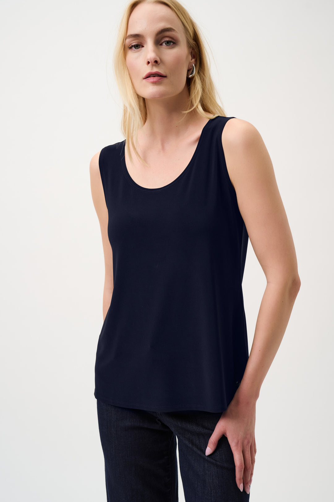 Woman wearing a black sleeveless tank top with a scoop neck on a white background