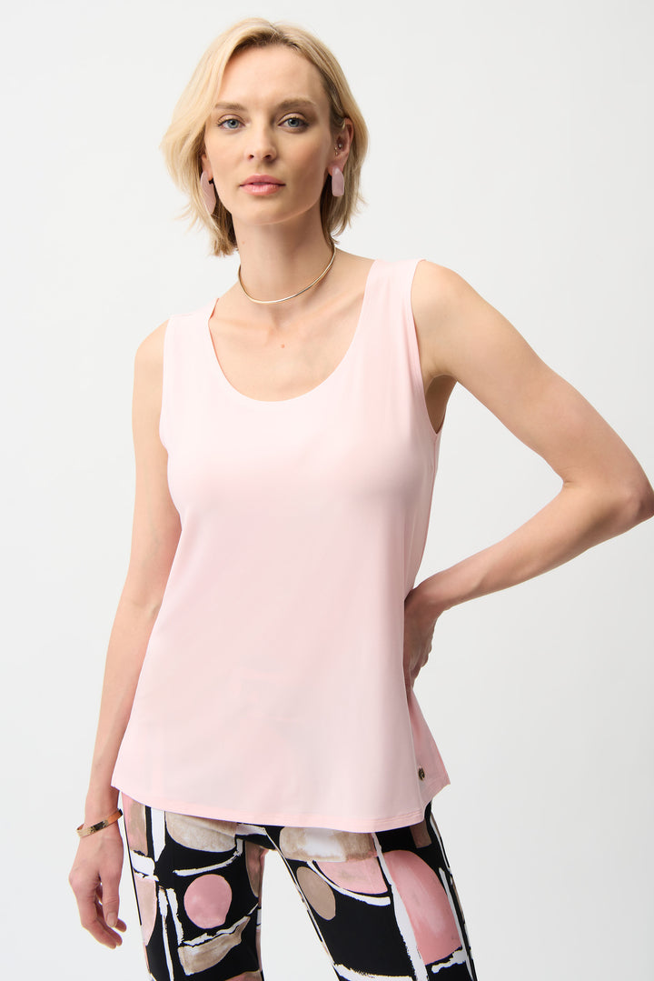 Woman wearing a light pink sleeveless tank top on a white background