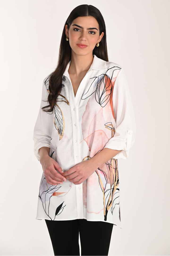 Woman wearing a white tunic blouse with floral patterns on a plain background