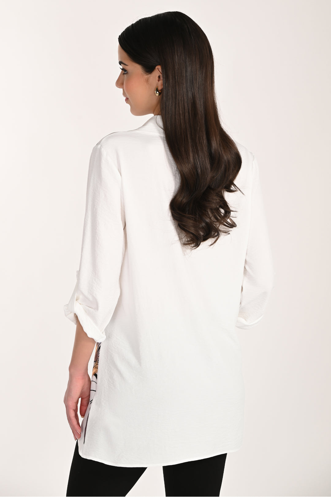 Woman wearing a white long-sleeve tunic blouse on a plain background