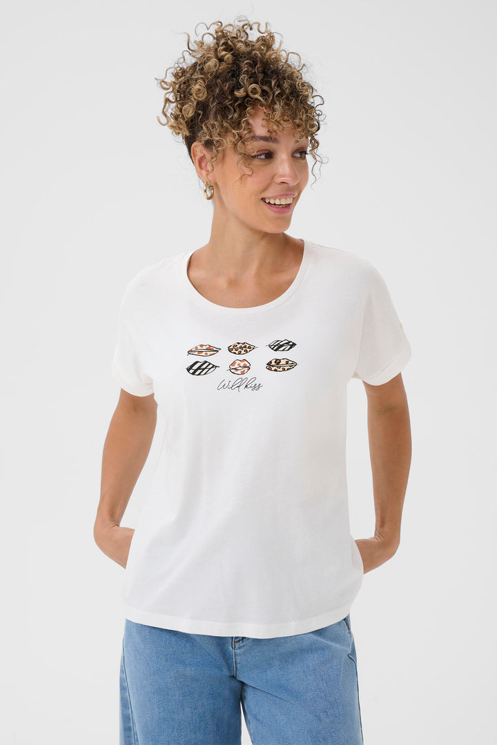 Woman wearing a white t-shirt with graphic designs on a plain background