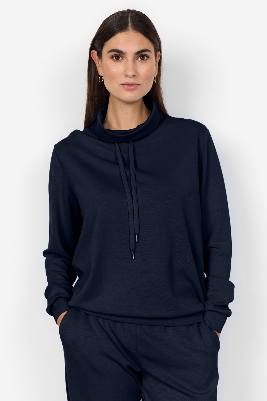 Woman wearing a navy blue hoodie and pants on a white background