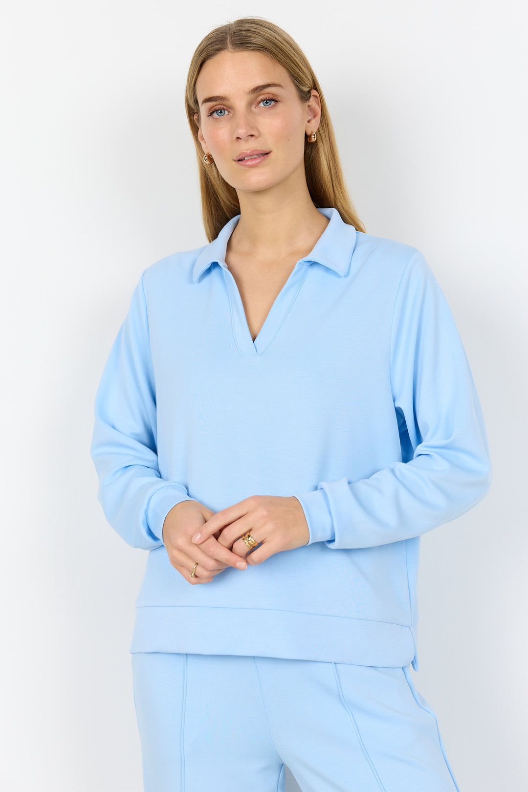 Woman wearing a light blue outfit against a white background
