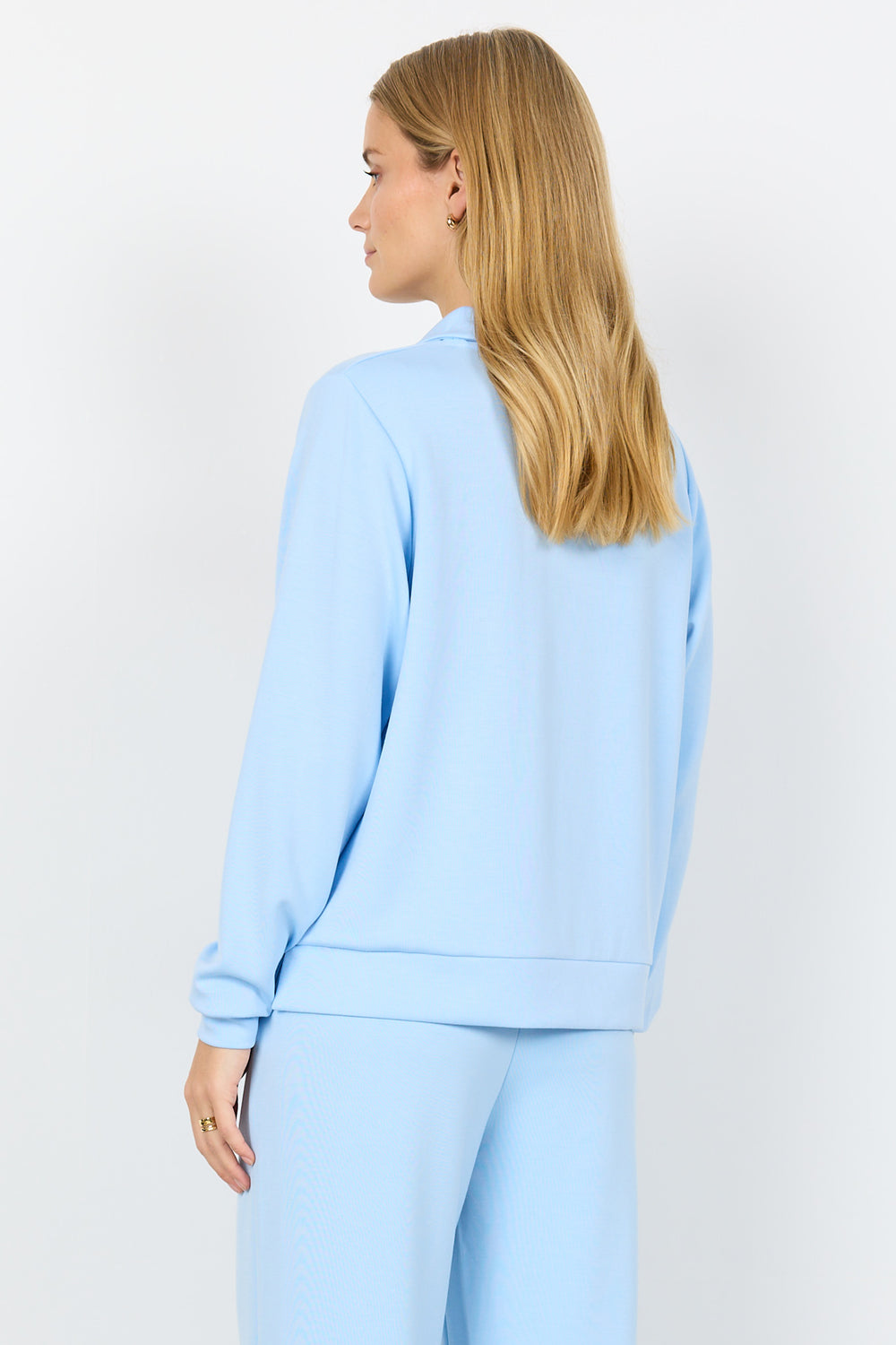 Woman wearing a light blue outfit on a white background