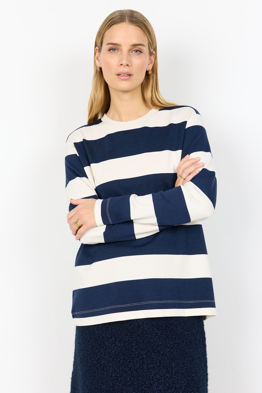 Woman wearing a navy and white striped sweater on a white background